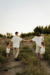 A family walking together through tall grass — clinical care and family therapy with Cheryl Donaldson